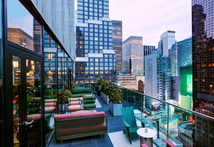 citizenM New York Times Square gay-friendly hotel rooftop view. Outdoor seating, skyscrapers, and city views. Perfect for gay travel.