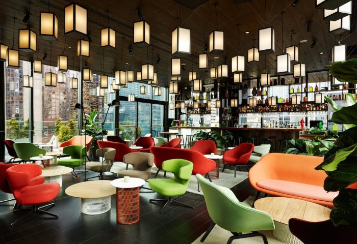 citizenM New York Times Square hotel's bar. Stylish interior with colorful chairs, tables, and a well-stocked bar. Gay-friendly hotel.