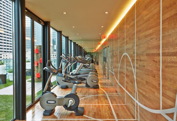 citizenM New York Times Square gay-friendly hotel gym. Exercise bikes with city view. Modern design, ideal for gay travelers.