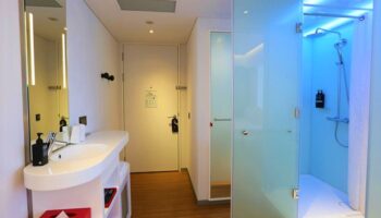 citizenM Taipei North Gate hotel bathroom with sink, mirror, and shower. Gay-friendly hotel with modern design for gay men travelers.