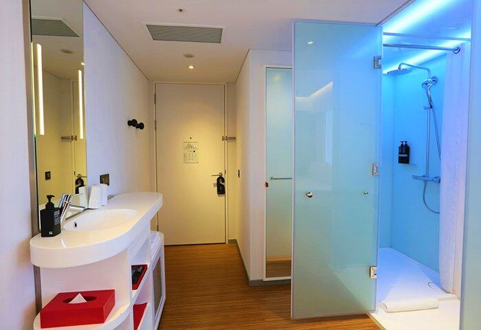 citizenM Taipei North Gate hotel bathroom with sink, mirror, and shower. Gay-friendly hotel with modern design for gay men travelers.