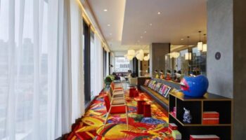 citizenM Taipei North Gate's stylish lounge area. This gay-friendly hotel features colorful decor, modern seating, & unique design elements.