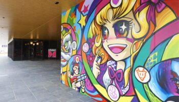 citizenM Taipei North Gate's exterior features vibrant, gay-friendly art. The hotel entrance is visible, inviting travelers.