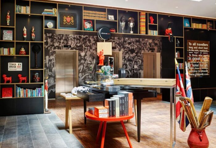 citizenM Tower of London lobby. Gay-friendly hotel with quirky decor, bookshelves, and a vibrant atmosphere. Ideal for gay travelers' London visit.