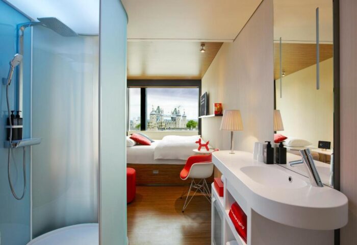 citizenM Tower of London hotel room. Modern design, shower, sink, and view of the Tower. Gay-friendly hotel choice for your London trip.