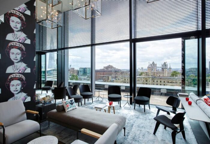 citizenM Tower of London hotel lounge. Gay-friendly hotel with views of London, and Queen Elizabeth II art. Modern design, comfortable seating.