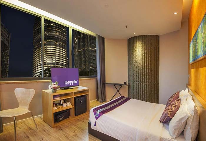 De King Boutique Hotel KLCC room. Gay-friendly hotel with city view. Modern interior, TV, bed, and Petronas Towers visible outside.