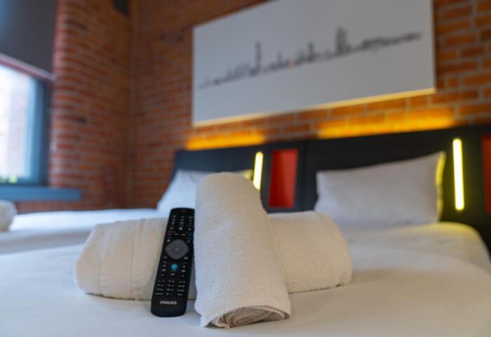 easyHotel Manchester room. Gay-friendly hotel with brick wall, skyline art, towels, remote. Comfy, clean, and modern for gay travelers.