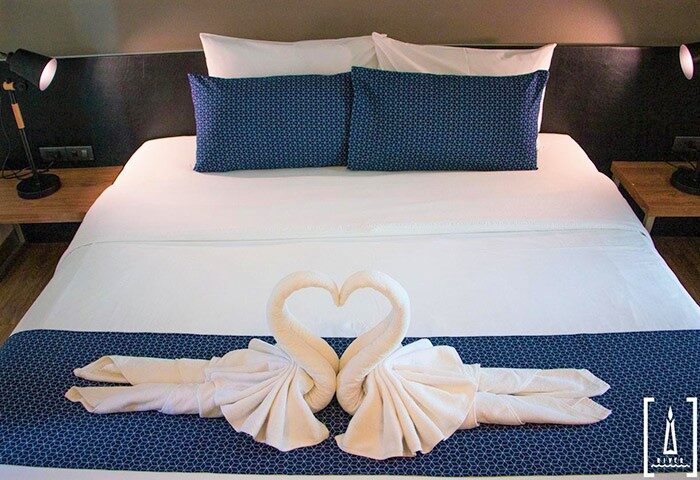 i-river Chiangmai gay-friendly hotel room. Bed with swan towels forming a heart. Gay travel in Thailand. Romantic getaway.