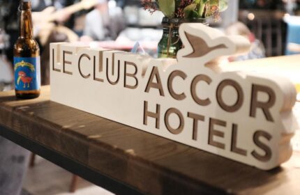 Ibis Amsterdam Centre hotel bar detail with Le Club Accor Hotels sign and beer. Gay-friendly, pet-friendly hotel for gay men travelers.