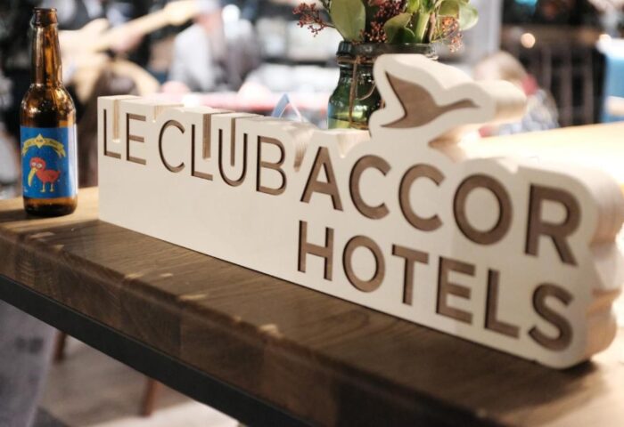 Ibis Amsterdam Centre hotel bar detail with Le Club Accor Hotels sign and beer. Gay-friendly, pet-friendly hotel for gay men travelers.