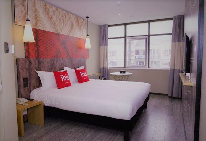 Ibis Beijing Tuanjiehu gay-friendly hotel room. Bed with Ibis pillows, bedside table, window, and modern decor. Comfortable stay in Beijing.