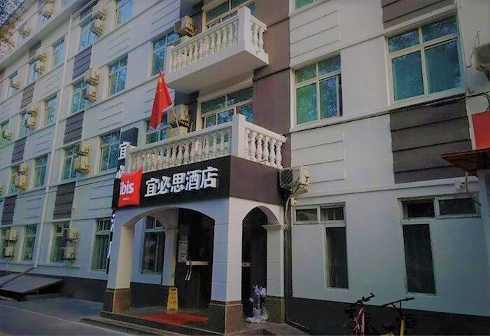 Exterior of the gay-friendly Ibis Beijing Tuanjiehu hotel. The facade features a balcony and the hotel's signage in Chinese and English.