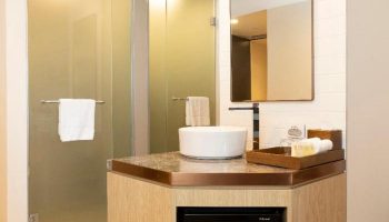Bathroom at ibis Melbourne Central, a gay-friendly hotel. Features a modern sink, shower, mirror, and amenities. Ideal for gay travelers.