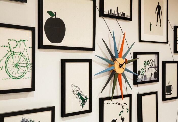 Wall art at ibis Styles Manchester Portland, a gay-friendly hotel. Features include framed prints and a starburst clock. Quirky decor.