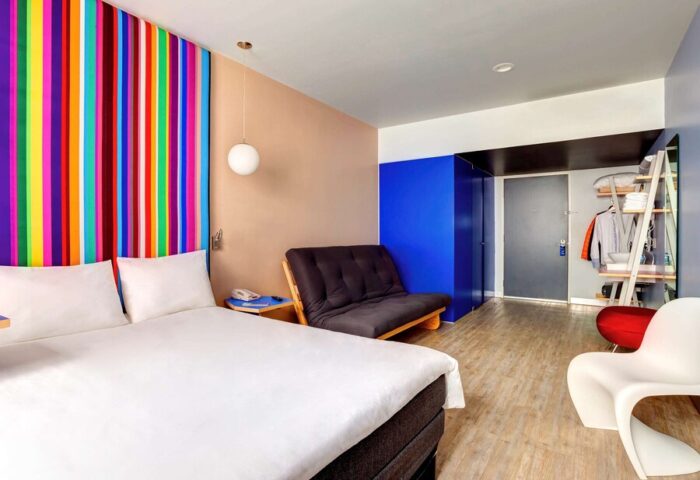 Gay-Friendly Hotel ibis Styles Mexico Reforma room. Colorful striped headboard, futon, and modern decor. Great for gay travel in Mexico City.