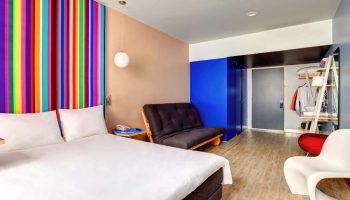Gay-Friendly Hotel ibis Styles Mexico Reforma room. Colorful striped headboard, futon, and modern decor. Great for gay travel in Mexico City.