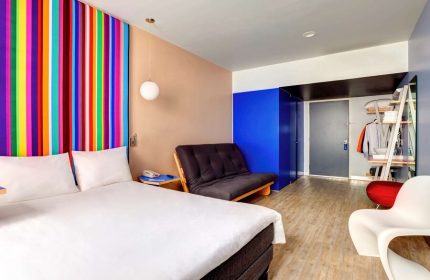 Gay-Friendly Hotel ibis Styles Mexico Reforma room. Colorful striped headboard, futon, and modern decor. Great for gay travel in Mexico City.