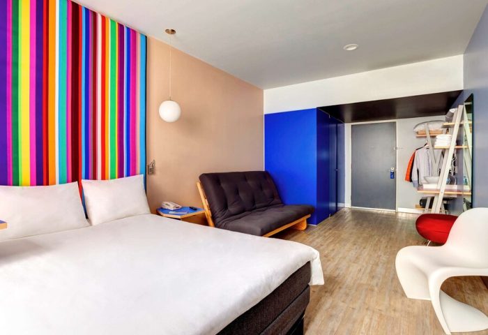 Gay-Friendly Hotel ibis Styles Mexico Reforma room. Colorful striped headboard, futon, and modern decor. Great for gay travel in Mexico City.