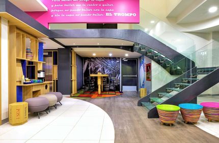 Ibis Styles Mexico Reforma's gay-friendly hotel lobby. Modern design with colorful accents, stairs, and seating areas. A welcoming space for gay travelers.