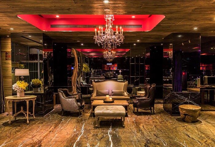 Inhouse Hotel's stylish lounge area. Gay-friendly hotel with a chandelier, elegant seating, and a warm, inviting atmosphere.