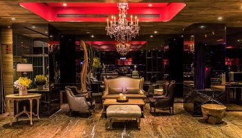 Inhouse Hotel's stylish lounge area. Gay-friendly hotel with a chandelier, elegant seating, and a warm, inviting atmosphere.