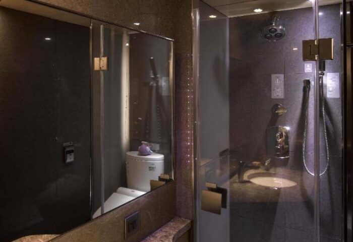 Inhouse Hotel's modern bathroom with glass shower. Gay-friendly hotel featuring a sleek design, ideal for gay men travel.