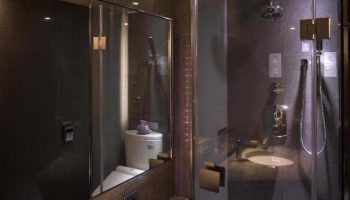Inhouse Hotel's modern bathroom with glass shower. Gay-friendly hotel featuring a sleek design, ideal for gay men travel.