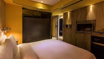 Inhouse Hotel room. Modern design, warm lighting, TV, and comfortable bed. Gay-friendly hotel, ideal for gay men travel.