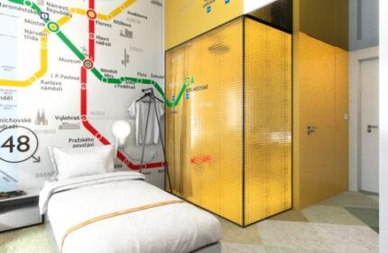 meetme23 gay-friendly hotel room. Pet-friendly stay with single bed, golden wardrobe, and Prague metro map design on the wall. Gay travel advice.