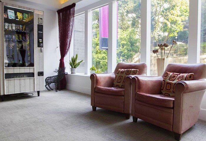 Lounge area at gay-friendly Mini Hotel Central: armchairs, vending machine, and window view. Ideal for gay travel in a central location.