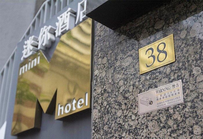 Mini Hotel Central entrance detail. Signage for this gay-friendly hotel, including the address number 38 and a surveillance warning.