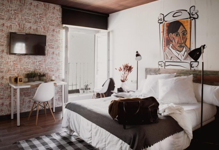 Room007 Chueca Hostel's gay-friendly room. Modern design, double bed, desk, TV, and balcony. Ideal for gay travel in Madrid, Spain.