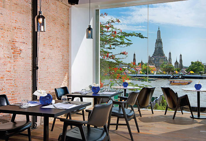 Sala Rattanakosin Bangkok gay-friendly hotel. Dining room view of Wat Arun temple over Chao Phraya River. Bangkok travel advice.
