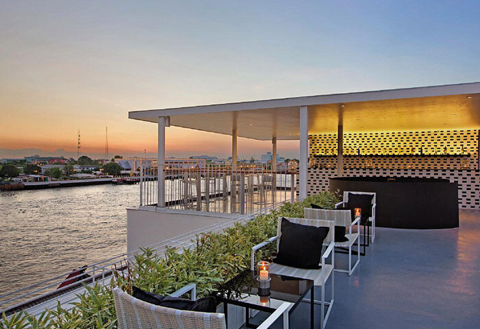 Sala Rattanakosin Bangkok gay-friendly hotel rooftop bar at sunset. Chao Phraya River view. Perfect for gay men travelers.