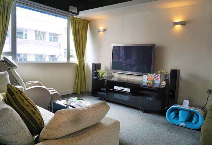 The Figo gay-friendly hotel room interior. A comfy lounge area with TV, massage chair, and modern decor. Ideal for gay men travel advice.