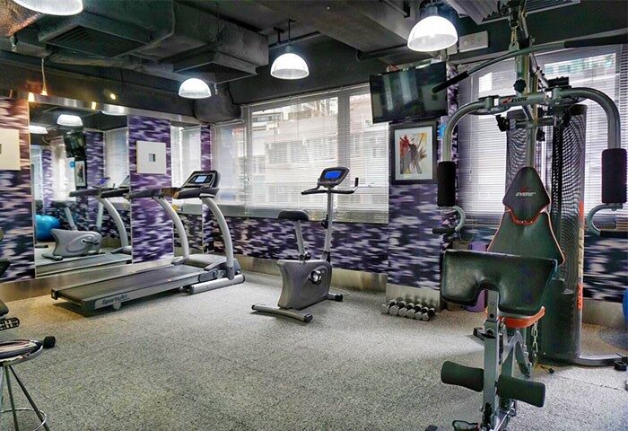 The Figo gay-friendly hotel gym. Fitness equipment includes a treadmill, stationary bike, and weight machine. For gay men's travel advice.