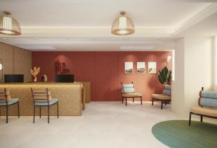 The Figo, a gay-friendly hotel. Lobby view with front desk, chairs, lighting fixtures, and wall art. Modern design for gay men's travel.