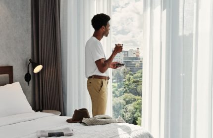 Le Meridien Melbourne hotel room view. Gay hotel in Collingwood. Man enjoying the view with a coffee. Gay travel advice.