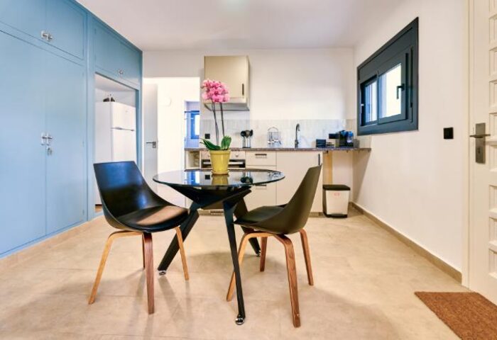 Casa Brisa Boutique Guest House kitchenette. Gay-owned space with table, chairs, and modern amenities. Ideal for gay travel lodging.