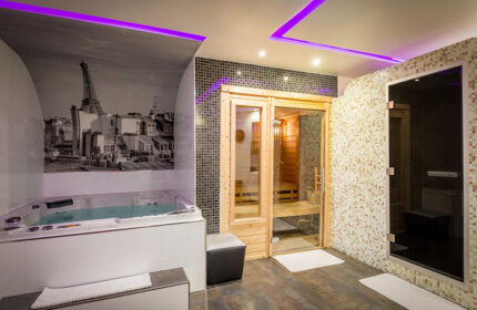 L'Empire Paris Hotel spa with jacuzzi, sauna, and steam room. Gay-popular hotel near gay bars. Eiffel Tower mural on the wall.