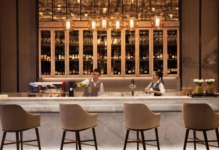 Bangkok Marriott Surawongse bar. Bartenders at gay-popular hotel near Silom's gay bars pour drinks. Stylish interior, inviting ambiance.