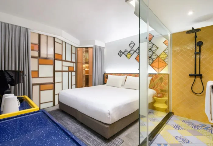 Ibis Styles Bangkok Silom hotel room. Stylish gay hotel with bed, shower, and colorful decor. Gay-friendly travel in Silom, Bangkok.
