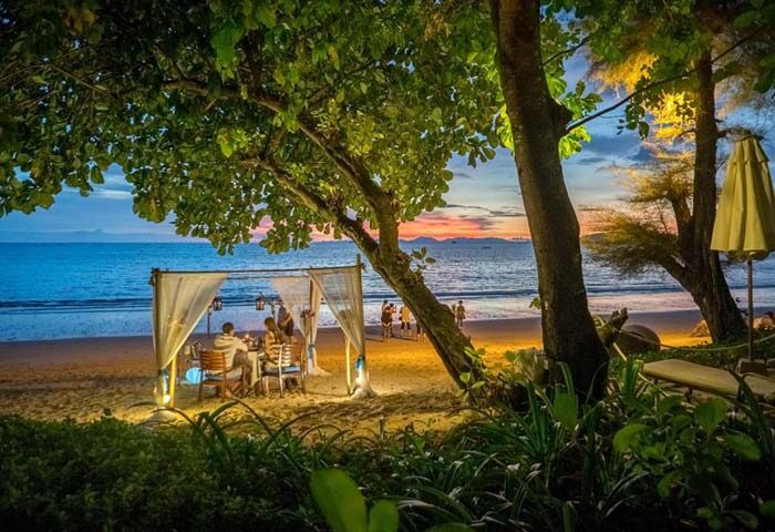 Romantic beach dinner at Centara Grand Krabi, a gay-friendly hotel. Sunset views, soft lighting, and intimate setting. Perfect for couples.