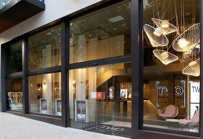 Facade of TWO Hotel Barcelona by Axel, an adults-only gay hotel in Eixample. Modern design, stylish lighting, and inviting entrance.