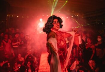 Drag queen performs at GenderFunk, Ho Chi Minh. Red lighting, crowd, and laser beams add to the atmosphere. Gay travel advice.