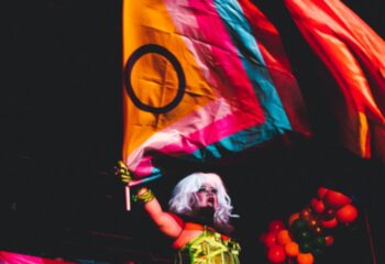 Drag queen waving a GenderFunk flag in Ho Chi Minh City. Gay travel to Vietnam. LGBTQ+ nightlife and events.