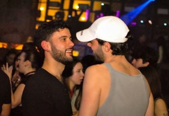 Two gay men at Glamorize Roma, a gay party in Rome, Italy. Nightlife scene with lights and people. Gay travel advice.
