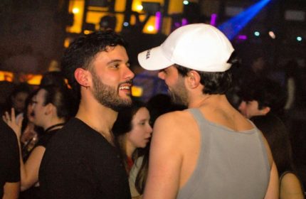 Two gay men at Glamorize Roma, a gay party in Rome, Italy. Nightlife scene with lights and people. Gay travel advice.