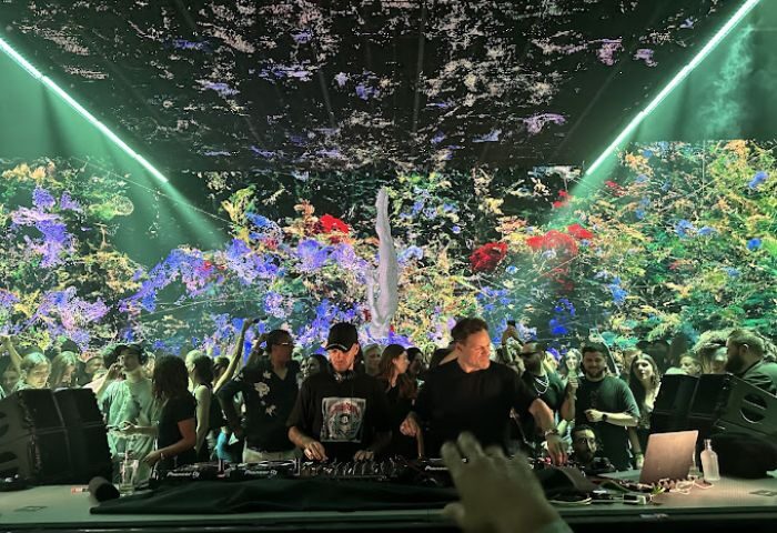 Glitterbox at Hï Ibiza gay club. DJs perform for a crowd under colorful lights. Gay nightlife travel destination for gay men.